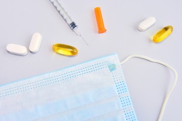 Pills, syringe, thermometer and protection mask on neutral background. Seasonal disease concept. Set for cold and flu treatment. Coronavirus Covid-19