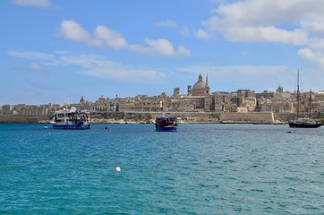 Fototapeta premium The medieval limestone city of Valletta with its main symbols - bell tower of St Paul Pro-Cathedral and large dome of Carmelite church, Malta