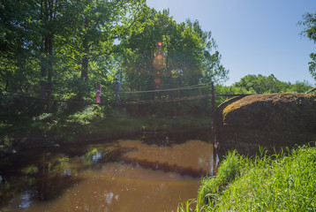 Big boulder ("Velna skroderis") next to small river in Latvia countryside