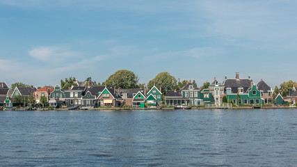Fototapeta na wymiar Dutch colorful wooden houses at a river in Zaandam