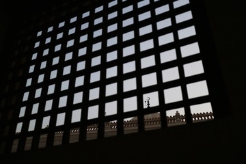 Crescent on mosque dome seen through square lattice window