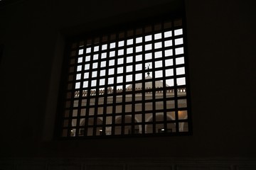 Crescent on mosque dome seen through square lattice window