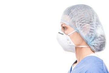 Side view of female medical specialist in protective mask and surgical cap against white background