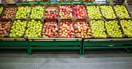 Apples in the cardboard boxes on the grocery shelf