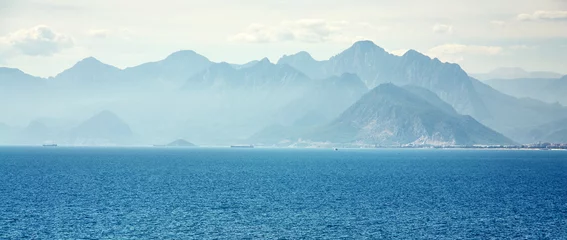 Fotobehang Slaapkamer schilderachtig landschap met zee, bergen en wolken. blauwe natuur van een baai.  © bakharev