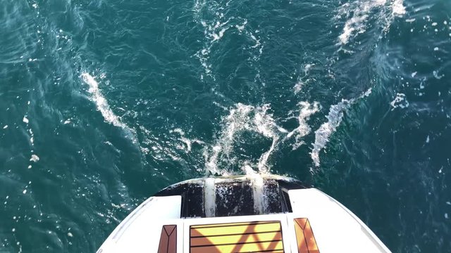 White Sailing Catamaran Yacht walking near Jeju island. Surf, waves and rocks from yacht boat.