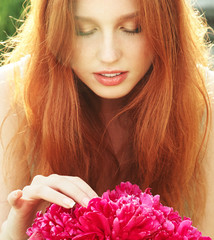 Naklejka premium summer closeup portrait of a young redhead woman with flowers