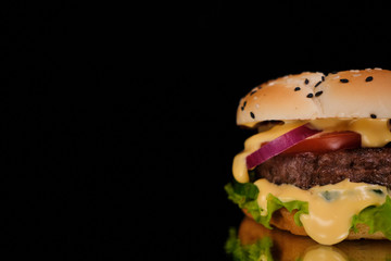 Close up. Delicious Burger with meat cutlet and vegetables on a black background. Copy space.
