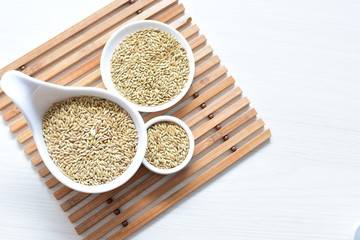 Seed of birdseed, food for birds, displayed in containers on white wooden background