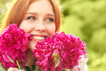 summer closeup portrait of a young redhead woman with flowers