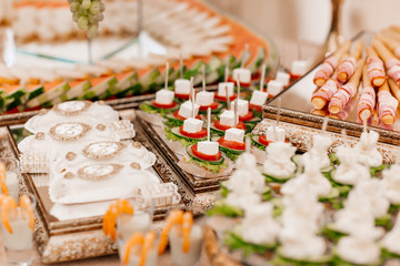 Original appetizer of canap with salted herring and cards of the potato. Rustic. Close-up.wedding...
