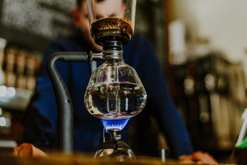 brewing coffee siphon. step by step cooking instructions. coffee is ready. Barista pouring brewed coffee in the cup