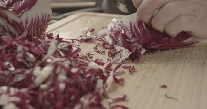 tagliare del radicchio su tagliere cucina italiana 