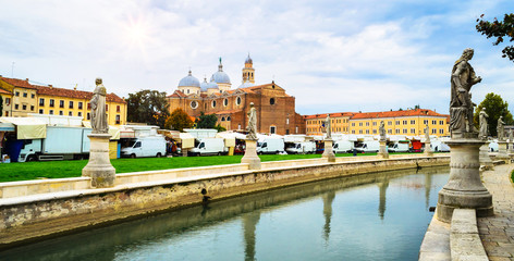 Canal with statues on square Prato della Valle and Basilica di Sant'Antonio in Padova (Padua), Veneto, Italy