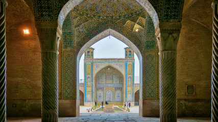 Tourists in courtyard of Vakil Mosque as seen from the hall of prayer, Shiraz, Iran