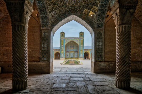 Tourists in courtyard of Vakil Mosque as seen from the hall of prayer, Shiraz, Iran