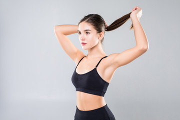 Pretty sportswoman holding up her ponytail isolated over white background