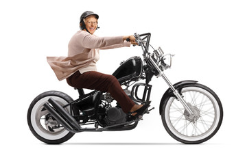 Fototapeta na wymiar Senior woman riding a custom chopper motorbike and smiling at camera