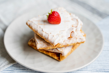 Waffles and strawberries on a grey wooden background. Dessert with berries.