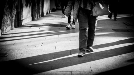 piernas  con sombra caminando por la calle