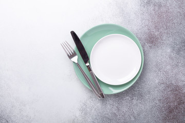 Empty mint and white plates knife and fork on stone background Copy space Top view