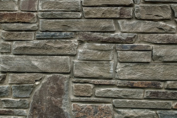 The wall is made of rough natural stone. Gray wall