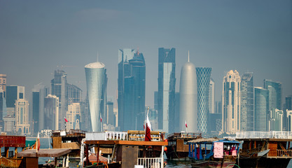 Panoramic view of modern skyline of Doha with old fishing boats foreground