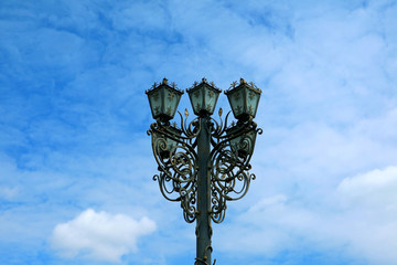 Fototapeta na wymiar Gorgeous vintage style wrought iron streetlamp against blue sky