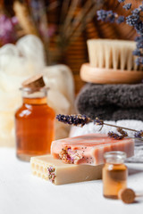 Concept of natural organic spa products, decor for bath. Home body treatment. Handmade herbal soap, organic oil in glass bottle, lavender, brush, towels. Atmosphere of relax, serenity and pleasure. 