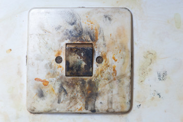 Close up of old plastic light switch covered in paint