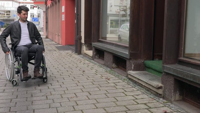 a man in a wheelchair cannot drive into a small shop