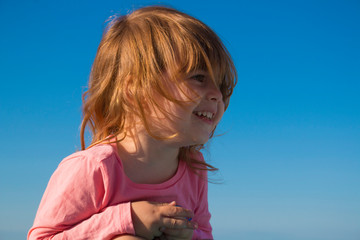 laughing little girl on a background of the sky