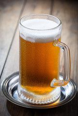Light beer in a glass on a table in composition with accessories on an old background