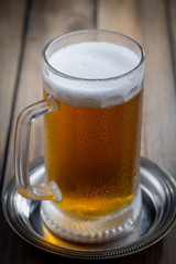 Light beer in a glass, on an old background.