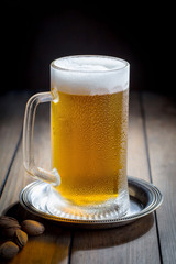Light beer in a glass on a table in composition with accessories on an old background