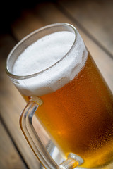 Light beer in a glass on a table in composition with accessories on an old background