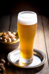 Light beer in a glass on a table in composition with accessories on an old background