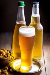 Light beer in a glass on a table in composition with accessories on an old background