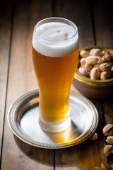 Light beer in a glass on a table in composition with accessories on an old background