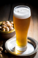 Light beer in a glass on a table in composition with accessories on an old background