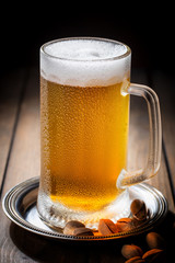 Light beer in a glass, on an old background. 