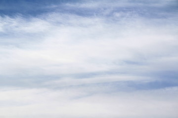 Cloudy blue sky with white and gray clouds. Background for text and design.