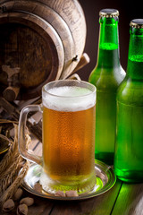 Light beer in a glass on a table in composition with accessories on an old background