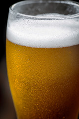 Light beer in a glass on a table in composition with accessories on an old background