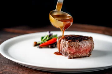 Rolgordijnen Grilled beef tenderloin steak on a white platter is served with demiglas sauce © Andrey