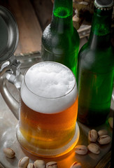Light beer in a glass on a table in composition with accessories on an old background