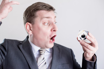 Nervous businessman in suit holds in hands drop of black oil of Brent brand, screams and shouts....