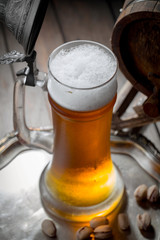 Light beer in a glass on a table in composition with accessories on an old background