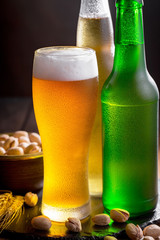 Light beer in a glass on a table in composition with accessories on an old background