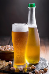 Light beer in a glass on a table in composition with accessories on an old background
